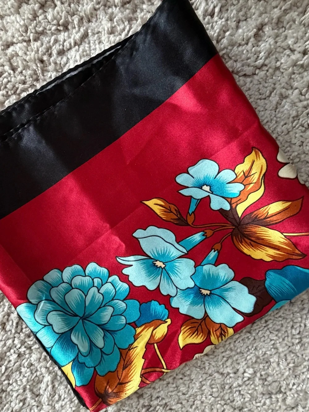 red and black silk like square scarf features a bold turquoise and blue